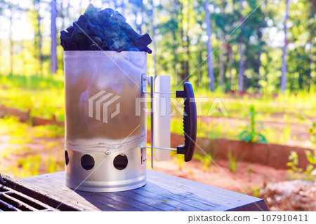 BBQ chimney starter is used to get charcoal ready for grill so that it is glowing hot when you turn it on 107910411