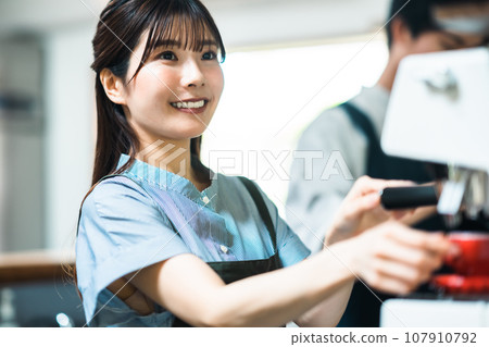 Young men and women working in a cafe 107910792