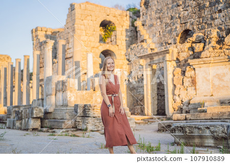 Pretty tourist woman at the ruins of ancient city of Perge near Antalya Turkey 107910889