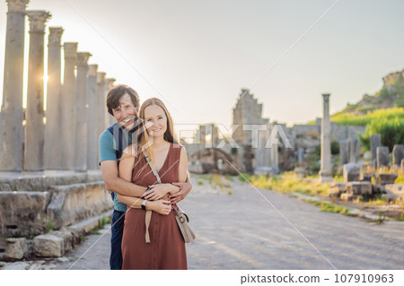 Loving couple of tourists at the ruins of ancient city of Perge near Antalya Turkey. Traveling with kids concept Loving couple of tourists at the ruins of ancient city of Perge near Antalya Turkey. Traveling with kids concept 107910963