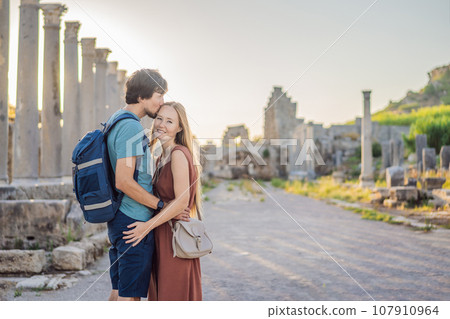 Loving couple of tourists at the ruins of ancient city of Perge near Antalya Turkey. Traveling with kids concept 107910964