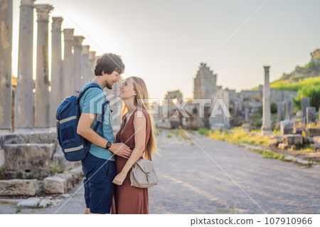 Loving couple of tourists at the ruins of ancient city of Perge near Antalya Turkey. Traveling with kids concept Loving couple of tourists at the ruins of ancient city of Perge near Antalya Turkey. Traveling with kids concept 107910966