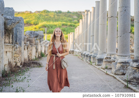 Pretty tourist woman at the ruins of ancient city of Perge near Antalya Turkey 107910981
