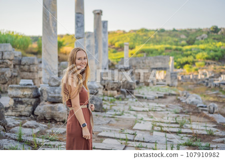 Pretty tourist woman at the ruins of ancient city of Perge near Antalya Turkey Pretty tourist woman at the ruins of ancient city of Perge near Antalya Turkey 107910982