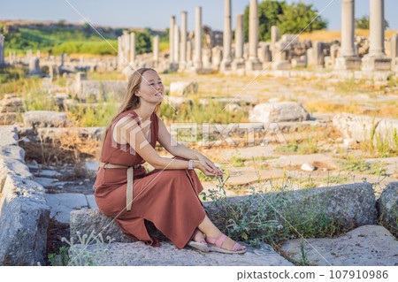 Pretty tourist woman at the ruins of ancient city of Perge near Antalya Turkey 107910986