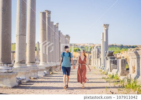Loving couple of tourists at the ruins of ancient city of Perge near Antalya Turkey. Traveling with kids concept 107911042