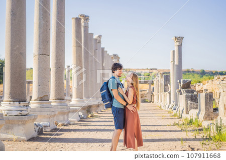 Loving couple of tourists at the ruins of ancient city of Perge near Antalya Turkey. Traveling with kids concept Loving couple of tourists at the ruins of ancient city of Perge near Antalya Turkey. Traveling with kids concept 107911668