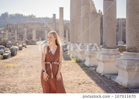 Pretty tourist woman at the ruins of ancient city of Perge near Antalya Turkey 107911670