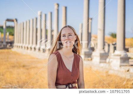 Pretty tourist woman at the ruins of ancient city of Perge near Antalya Turkey 107911705