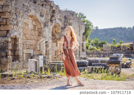 Pretty tourist woman at the ruins of ancient city of Perge near Antalya Turkey 107911718