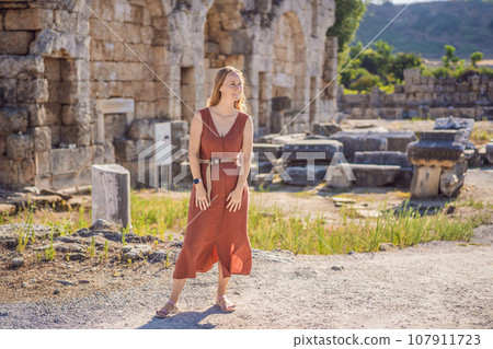 Pretty tourist woman at the ruins of ancient city of Perge near Antalya Turkey 107911723