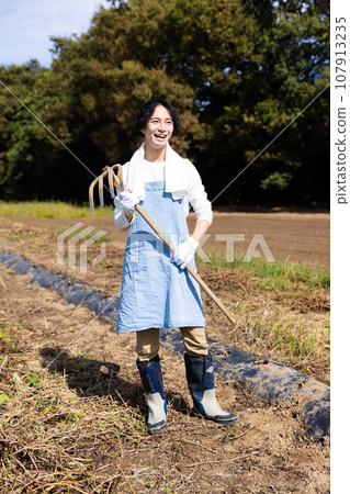 young man plowing the field 107913235