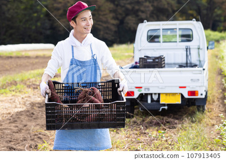 一名男子從地裡運蔬菜 107913405