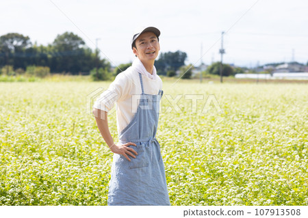 A young man standing in a buckwheat field 107913508