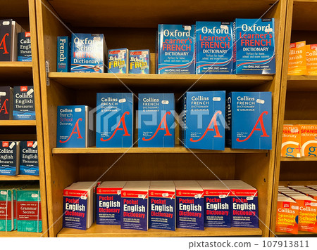Multi-colored dictionaries and grammars of French and English are on the shelves in the store 107913811
