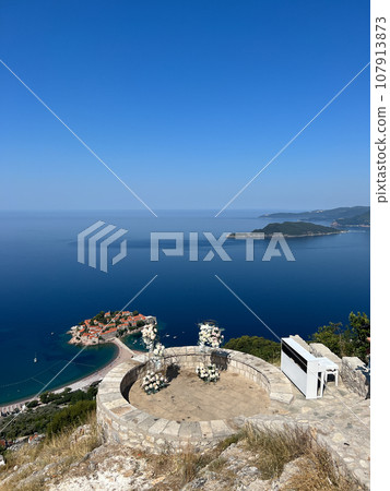 Piano and a wedding semi-arch stand on the observation deck above the island of Sveti Stefan. Montenegro Piano and a wedding semi-arch stand on the observation deck above the island of Sveti Stefan. Montenegro 107913873