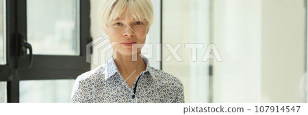 Positive woman looks in camera holding laptop in hands 107914547