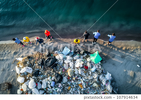Group of volunteers cleaning garbages on the beach, birds eyes view, generative AI. Group of volunteers cleaning garbages on the beach, birds eyes view, generative AI. 107914634