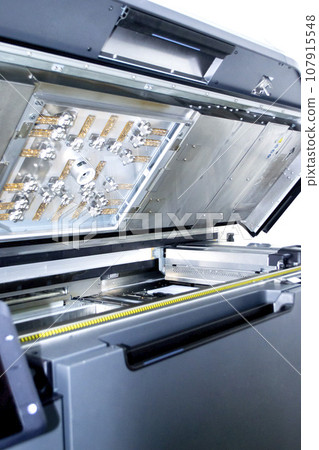 Top of large industrial printer with lid open. Multi Jet Fusion. Large industrial 3D printer printing polyimide powder. Industrial equipment. New modern 3D printing additive progressive technology MJF Top of large industrial printer with lid open. Multi Jet Fusion. Large industrial 3D printer printing polyimide powder. Industrial equipment. New modern 3D printing additive progressive technology MJF 107915548
