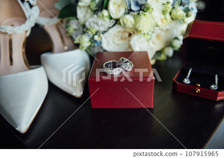 Wedding set of the bride. Shoes and rings lie next to the wedding bouquet Wedding set of the bride. Shoes and rings lie next to the wedding bouquet 107915965
