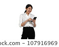 A woman in a suit operates a cell phone while laughing. 107916969