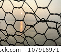 Sunset over the Ganges River in Varanasi, India through wire mesh 107916971