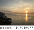 Sunset and old buildings over the Ganges river in Varanasi, India. 107916977