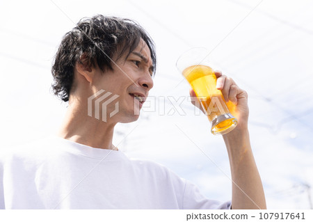 一個清爽的男人喝著啤酒，看起來很可口 107917641