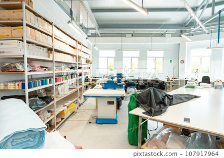 Interior of a sewing warehouse of furniture factory with equipment and materials Interior of a sewing warehouse of furniture factory with equipment and materials 107917964