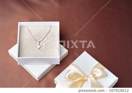 White jewelry boxes on brown silk background White jewelry boxes on brown silk background 107918012