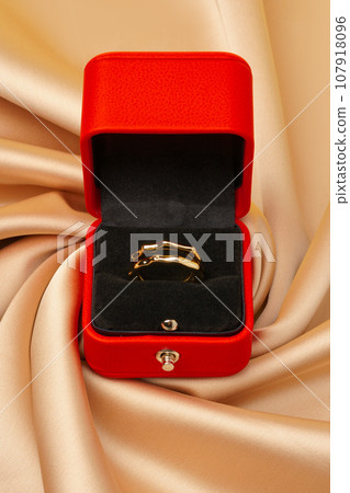 Golden ring in red jewelry box close up 107918096
