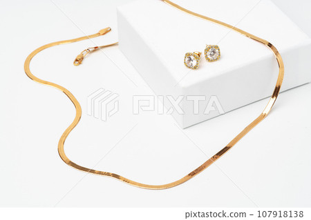Golden diamond neacklace and earrings on white background Golden diamond neacklace and earrings on white background 107918138