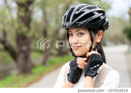 young woman wearing a cycling helmet young woman wearing a cycling helmet 107918819