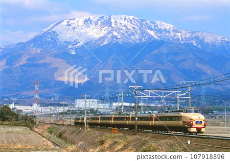 Limited express "Shirasagi" running towards Nagoya with Mt. Ibuki in the background 107918896