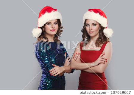Beautiful glamorous Christmas women wearing red Santa hat, Xmas portrait 107919607