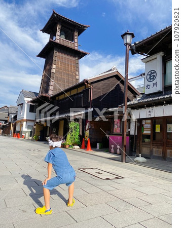 A boy watches the bell of time in Kawagoe, Little Edo early in the morning A boy watches the bell of time in Kawagoe, Little Edo early in the morning 107920821