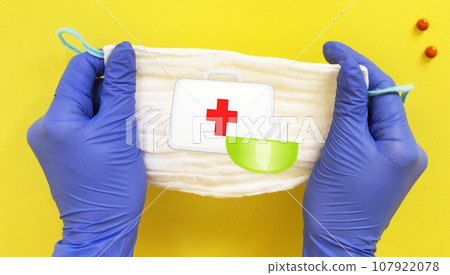 Hand of doctor, nurse or scientist in blue nitrile gloves holding a medical mask Hand of doctor, nurse or scientist in blue nitrile gloves holding a medical mask 107922078