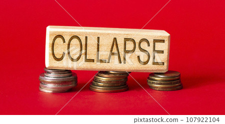 on wooden cubes text collapse with coins on a red background on wooden cubes text collapse with coins on a red background 107922104