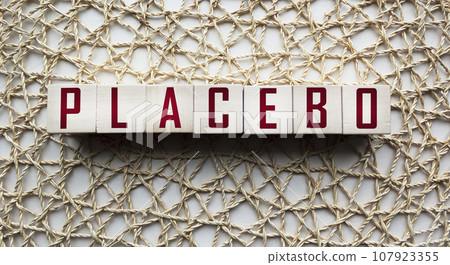 PLACEBO, the inscription on wooden cubes on an openwork background 107923355
