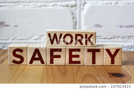WORK SAFETY written on wooden blocks against white brick wall 107923423