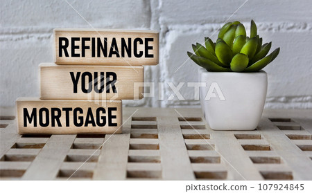 Business concept. Text REFINANCING YOUR MORTGAGE on wooden blocks and beautiful background Business concept. Text REFINANCING YOUR MORTGAGE on wooden blocks and beautiful background 107924845