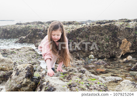 Little girl Eastbourne, East Sussex. Beach and sea in foggy morning Little girl Eastbourne, East Sussex. Beach and sea in foggy morning 107925204