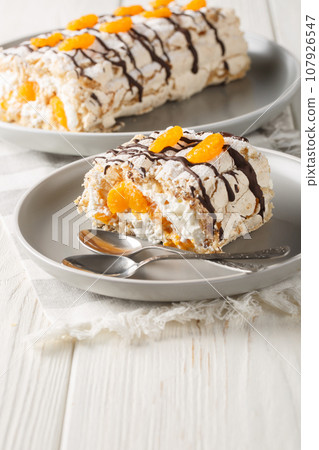 Classic gluten-free Budapest roll cake with mandarins closeup on the plate. Vertical Classic gluten-free Budapest roll cake with mandarins closeup on the plate. Vertical 107926547