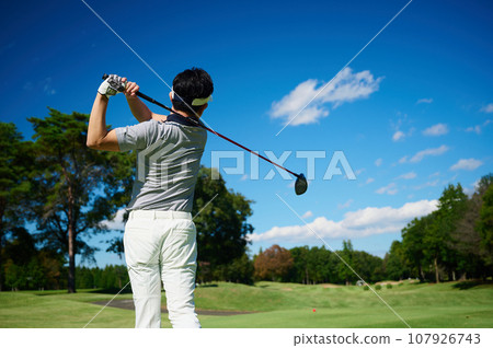 A man enjoying golf under a sunny blue sky 107926743