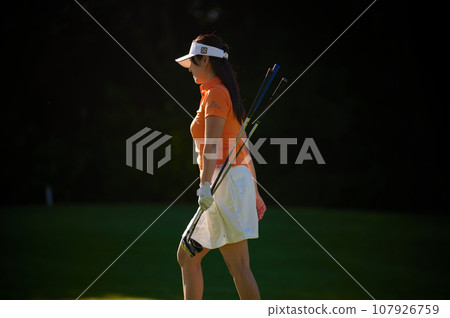 Black background, woman enjoying golf 107926759