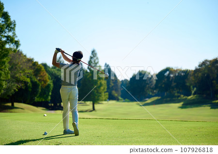 A man in his 40s playing golf 107926818