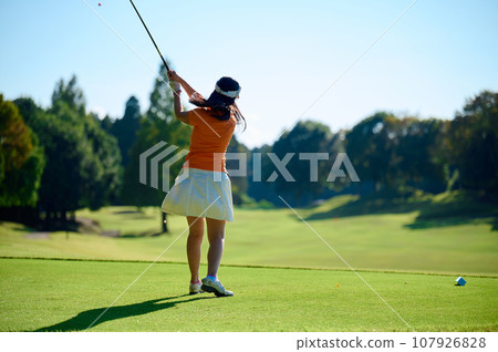 Woman hitting a tee shot Woman hitting a tee shot 107926828