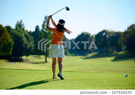 Woman hitting a tee shot 107926830