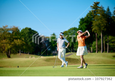 A couple enjoying golf under the blue sky 107927362
