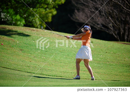 A woman enjoying golf under the blue sky A woman enjoying golf under the blue sky 107927363